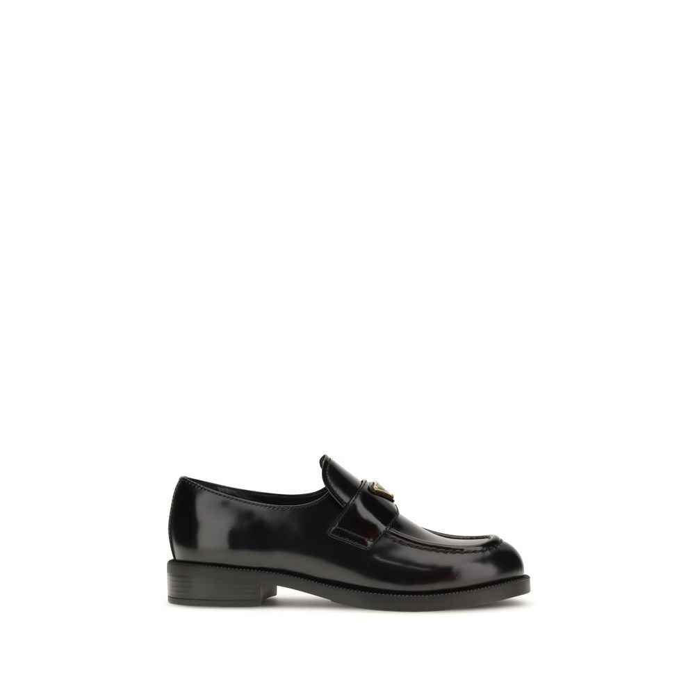 Schwarze Leder-Slipper mit Metallemblem