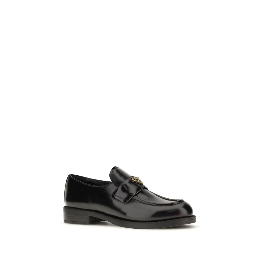 Schwarze Leder-Slipper mit Metallemblem