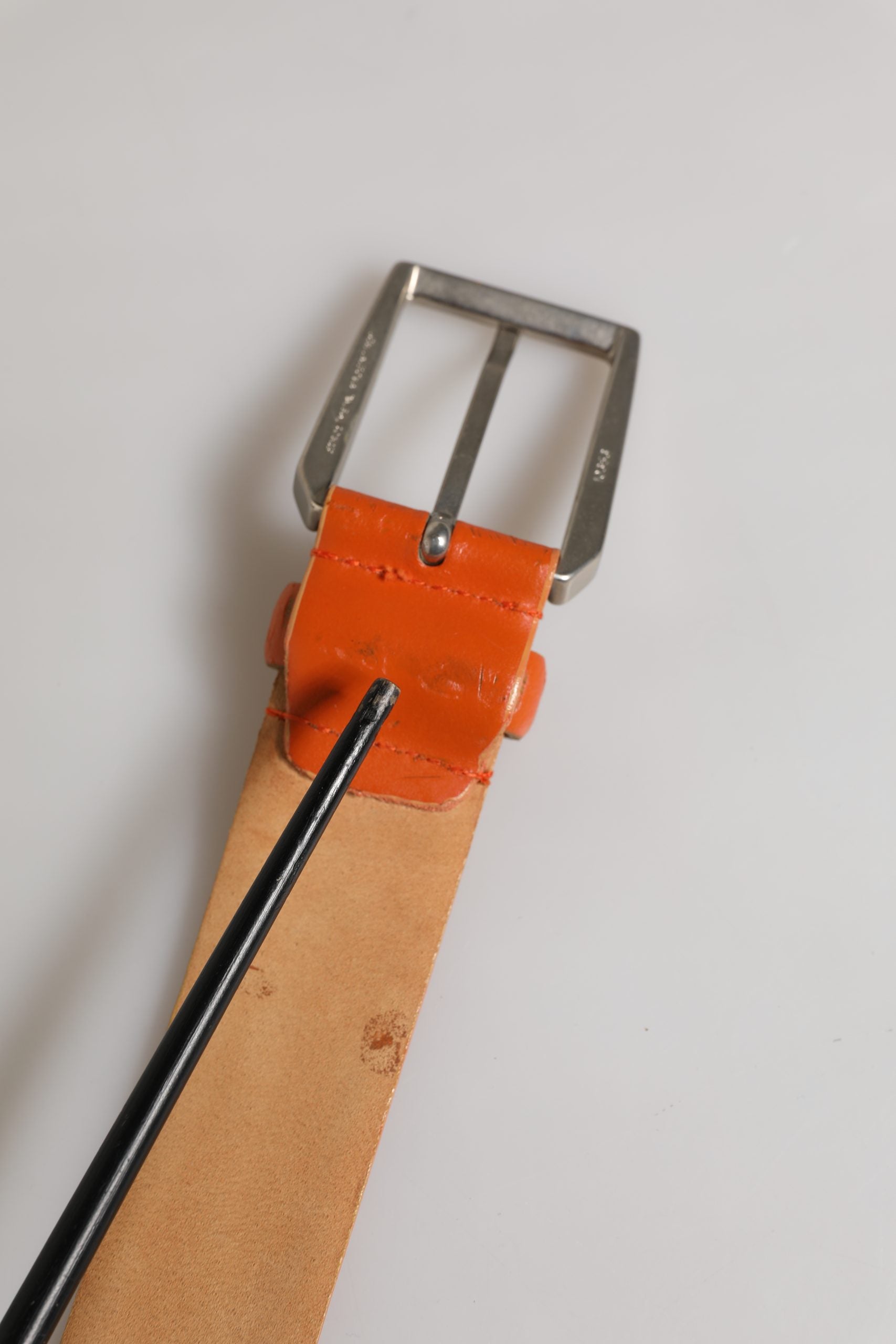 Oranger Ledergürtel mit silberner Metallschnalle