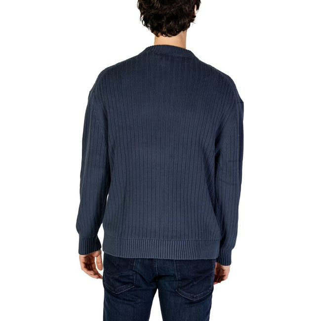 Blue Cotton SweaterThe Calvin Klein Jeans LINEAR J30J326193 men’s sweater is a must-have knitwear piece, combining contemporary style with comfort. Crafted from 100% pure cotton, it provides a soft and pleasant feel against the skin, making it ideal for t