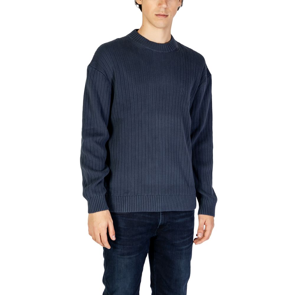 Blue Cotton SweaterThe Calvin Klein Jeans LINEAR J30J326193 men’s sweater is a must-have knitwear piece, combining contemporary style with comfort. Crafted from 100% pure cotton, it provides a soft and pleasant feel against the skin, making it ideal for t
