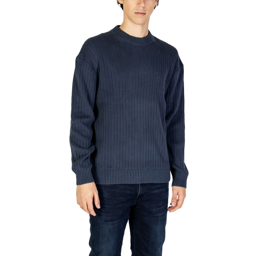 Blue Cotton SweaterThe Calvin Klein Jeans LINEAR J30J326193 men’s sweater is a must-have knitwear piece, combining contemporary style with comfort. Crafted from 100% pure cotton, it provides a soft and pleasant feel against the skin, making it ideal for t