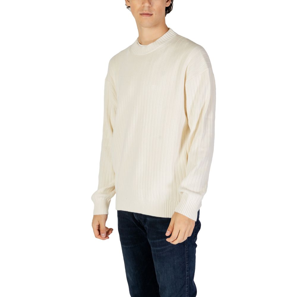 Cream Cotton SweaterThe Calvin Klein Jeans LINEAR J30J326193 men’s sweater is a must-have knitwear piece, combining contemporary style with comfort. Crafted from 100% pure cotton, it provides a soft and pleasant feel against the skin, making it ideal for