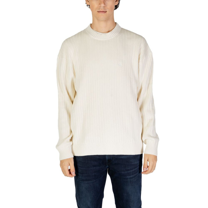Cream Cotton SweaterThe Calvin Klein Jeans LINEAR J30J326193 men’s sweater is a must-have knitwear piece, combining contemporary style with comfort. Crafted from 100% pure cotton, it provides a soft and pleasant feel against the skin, making it ideal for