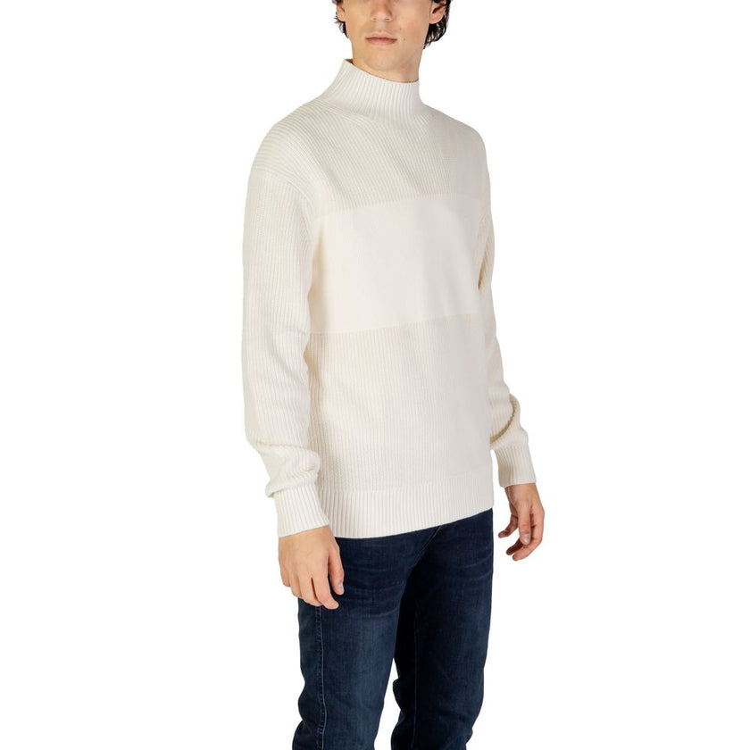 Cream Cotton SweaterThe Calvin Klein Jeans MIXED STITCH HIGH J30J326204 men’s sweater is an elegant and contemporary choice for those seeking both style and comfort. Crafted from a premium blend of 90% cotton and 10% polyester, this sweater offers a soft,