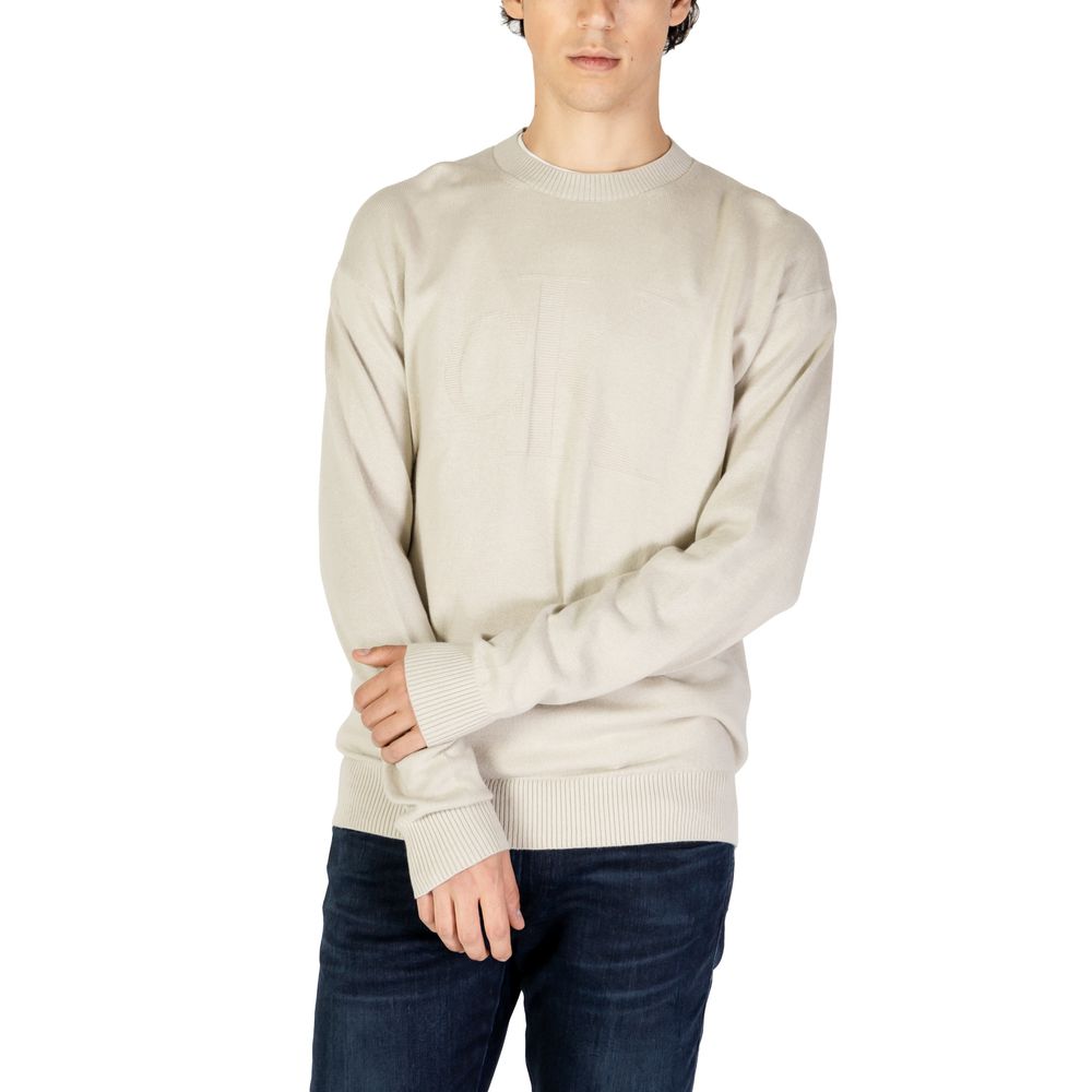 Beige Organic Cotton SweaterThe Calvin Klein Jeans CK INTARSIA MIX J30J326453 men’s sweater combines elegance and comfort in a timeless design. Crafted from a premium blend of 55% organic cotton, 35% cotton, and 10% wool, this sweater ensures a soft feel