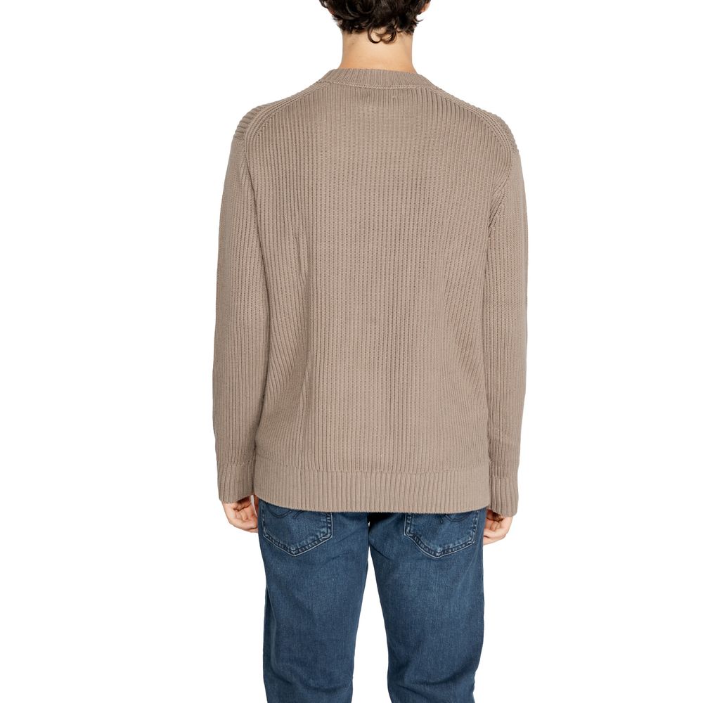 Brown Organic Cotton SweaterThe Calvin Klein Jeans RELAXED LINEAR J30J326888 men’s sweater is the perfect choice for those seeking a casual yet contemporary look without compromising on quality. Crafted from 100% organic cotton, it offers a naturally soft