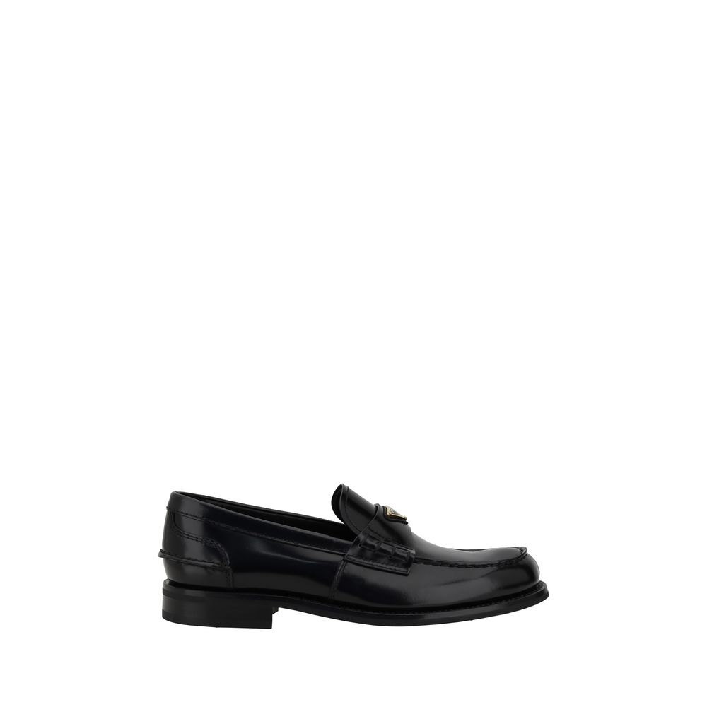 Black Calf Leather Bos Taurus Slip-On LoafersPrada’s leather Loafers are a mix of classic elegance and distinctive details. The slightly elongated round toe and leather block heel ensure comfort and style. The iconic enameled triangular plaque with the br