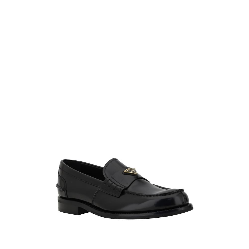 Black Calf Leather Bos Taurus Slip-On LoafersPrada’s leather Loafers are a mix of classic elegance and distinctive details. The slightly elongated round toe and leather block heel ensure comfort and style. The iconic enameled triangular plaque with the br