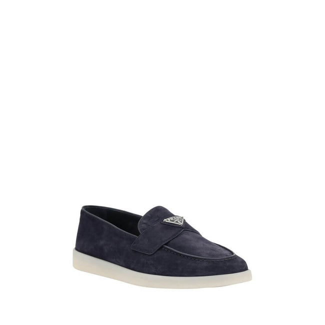 Blue Rubber Slip-On LoafersPrada’s leather Loafers feature an almond toe and a suede design that lends a touch of sophisticated elegance. The contrasting flat sole and front tray embellished with the brand’s iconic triangular plaque add a distinctive deta