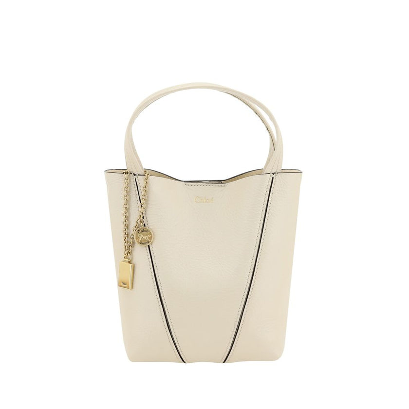 Beige Calf Leather Bos Taurus Shoulder BagThe Spin Shoulder Bag by Chloé, crafted by shiny grained leather, features an elegant design with two flat top handles and an adjustable shoulder strap. The closure is secured by a magnetic button, while the detai