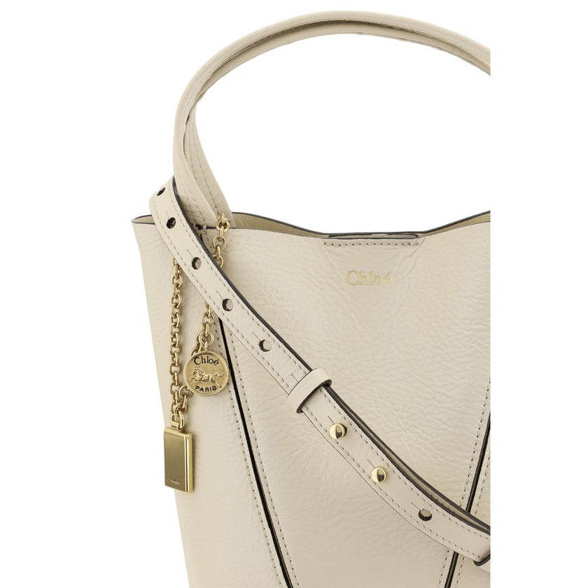 Beige Calf Leather Bos Taurus Shoulder BagThe Spin Shoulder Bag by Chloé, crafted by shiny grained leather, features an elegant design with two flat top handles and an adjustable shoulder strap. The closure is secured by a magnetic button, while the detai