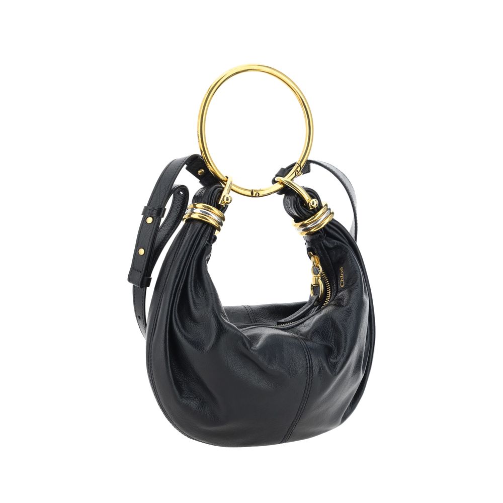 Black Calf Leather Bos Taurus HandbagLeather Bracelet Handbag by Chloé, a round brass handle, an adjustable flat shoulder strap and removable top zipper closure, single interior compartment. Season: AW25 Dimension: 32x32x10 Composition: 100% Calf Leather