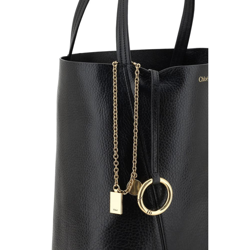 Black Calf Leather Bos Taurus Shoulder BagLeather Spin Shoulder Bag by Chloé is a refined and modern accessory featuring a sleek grained leather design. The two flat top handles offer a comfortable and practical grip, while the brand’s iconic monogram, pr