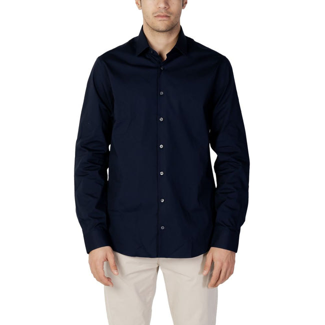 Blue Cotton Dress ShirtDiscover the long-sleeve men’s shirt by Calvin Klein, model POPLIN STRETCH SLIM. Made with a composition of 96% cotton and 4% elastane/lycra, this shirt offers exceptional comfort and a slim fit that enhances the male silhouette. Pe