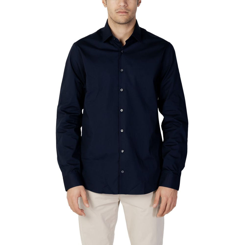 Blue Cotton Dress ShirtDiscover the long-sleeve men’s shirt by Calvin Klein, model POPLIN STRETCH SLIM. Made with a composition of 96% cotton and 4% elastane/lycra, this shirt offers exceptional comfort and a slim fit that enhances the male silhouette. Pe