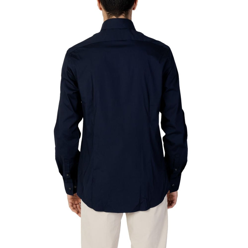 Blue Cotton Dress ShirtDiscover the long-sleeve men’s shirt by Calvin Klein, model POPLIN STRETCH SLIM. Made with a composition of 96% cotton and 4% elastane/lycra, this shirt offers exceptional comfort and a slim fit that enhances the male silhouette. Pe