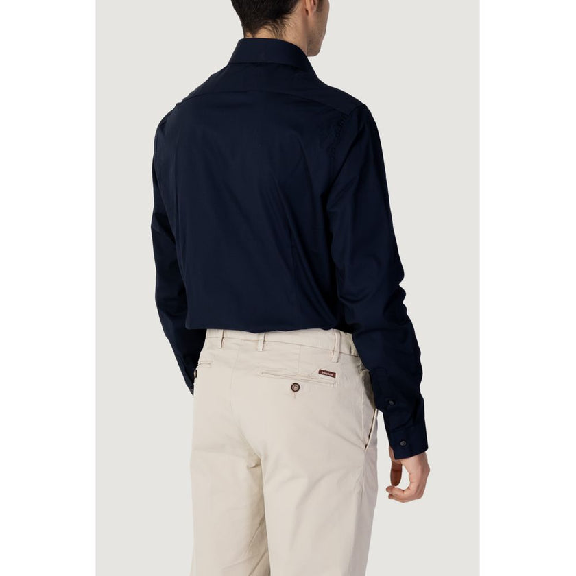 Blue Cotton Dress ShirtDiscover the long-sleeve men’s shirt by Calvin Klein, model POPLIN STRETCH SLIM. Made with a composition of 96% cotton and 4% elastane/lycra, this shirt offers exceptional comfort and a slim fit that enhances the male silhouette. Pe