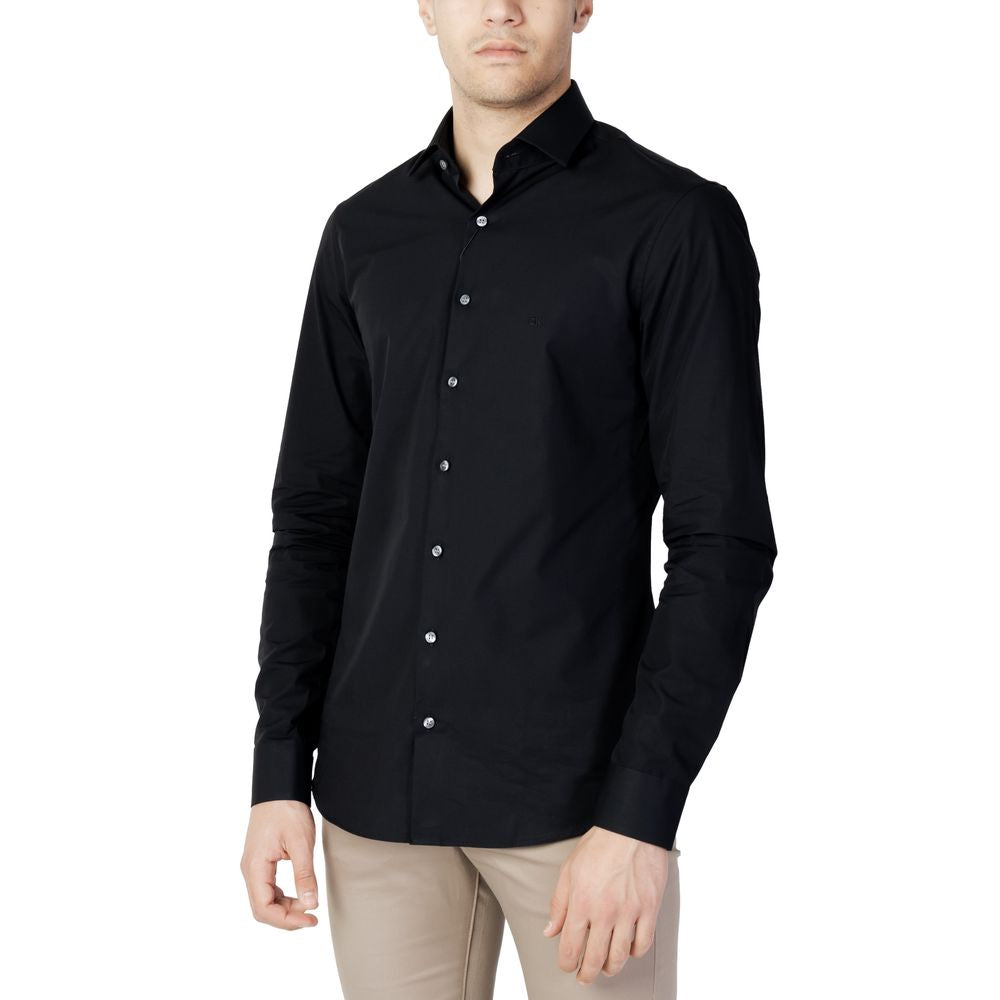 Black Cotton Dress ShirtThe Calvin Klein POPLIN STRETCH SLIM SHIRT K10K103025 for men is an elegant and modern shirt, perfect for those seeking a refined and contemporary style. Made from 100% high-quality poplin cotton, it features a slim fit that enhanc