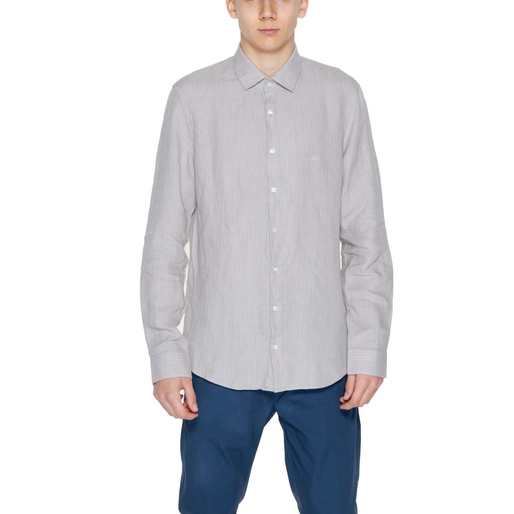 Beige Linen ShirtThe Calvin Klein K10K112887 men’s long-sleeved shirt is crafted from 100% linen, a natural fabric renowned for its lightness and breathability. This shirt features a relaxed fit and a classic design with a traditional collar and front but