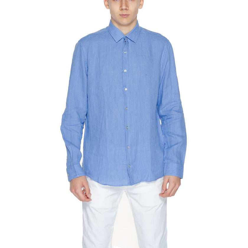 Blue Linen ShirtThe Calvin Klein K10K112887 men’s long-sleeved shirt is crafted from 100% linen, a natural fabric renowned for its lightness and breathability. This shirt features a relaxed fit and a classic design with a traditional collar and front butt