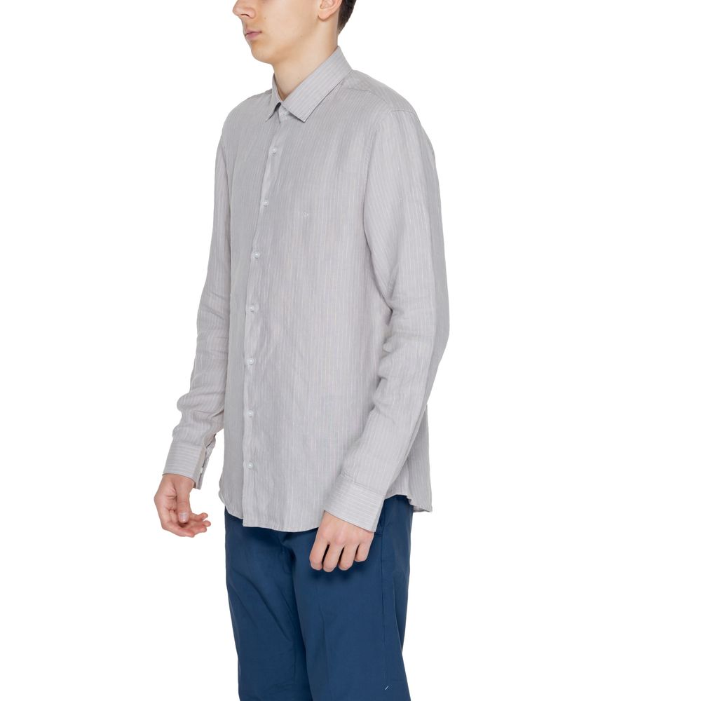 Beige Linen ShirtThe Calvin Klein K10K112887 men’s long-sleeved shirt is crafted from 100% linen, a natural fabric renowned for its lightness and breathability. This shirt features a relaxed fit and a classic design with a traditional collar and front but