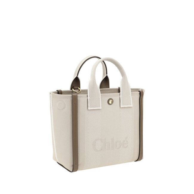 Beige Cotton Shoulder BagChloé’s Carry Tote Bag is a stylish, multifunctional accessory made of cotton with contrasting leather details that accentuate its sophisticated appeal. Magnetic buttons on the side panels allow you to adjust the width of the bag