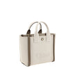 Beige Cotton Shoulder BagChloé’s Carry Tote Bag is a stylish, multifunctional accessory made of cotton with contrasting leather details that accentuate its sophisticated appeal. Magnetic buttons on the side panels allow you to adjust the width of the bag