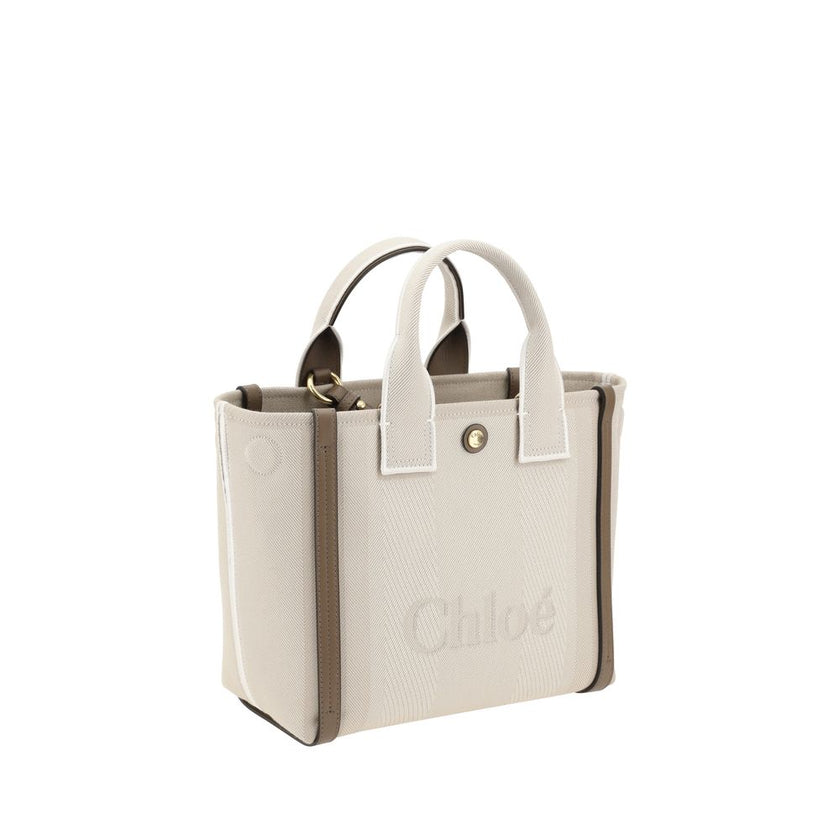 Beige Cotton Shoulder BagChloé’s Carry Tote Bag is a stylish, multifunctional accessory made of cotton with contrasting leather details that accentuate its sophisticated appeal. Magnetic buttons on the side panels allow you to adjust the width of the bag