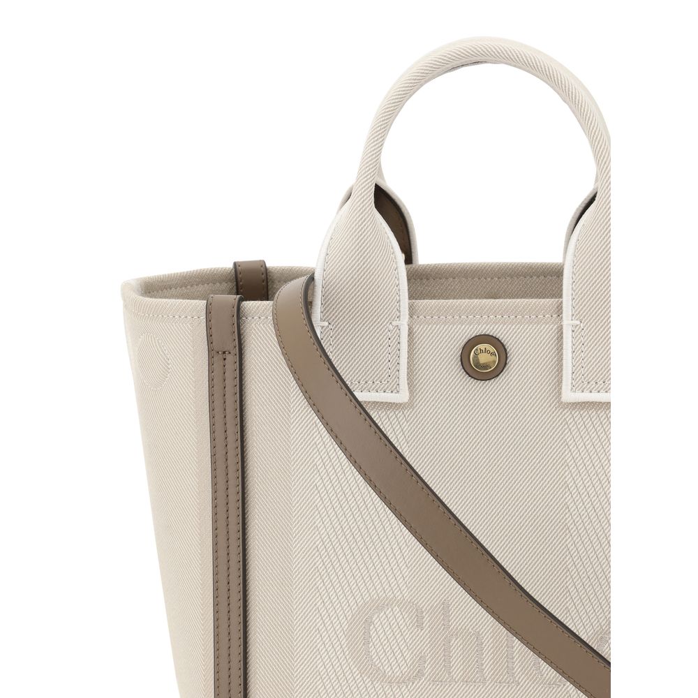 Beige Cotton Shoulder BagChloé’s Carry Tote Bag is a stylish, multifunctional accessory made of cotton with contrasting leather details that accentuate its sophisticated appeal. Magnetic buttons on the side panels allow you to adjust the width of the bag