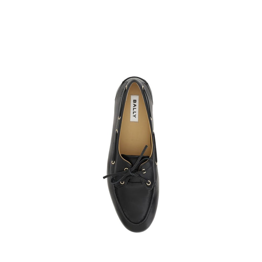 Black Calf Leather Bos Taurus Slip-On LoafersPathy leather Loafers by Bally feature an almond toe and a boat-inspired design, with a leather ribbon that ties at the front, adding an elegant and refined touch. The leather block heel offers stability and co