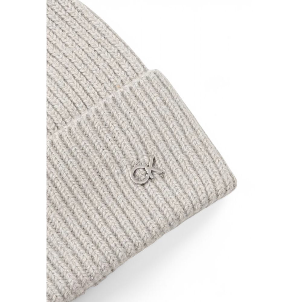 Gray Wool Cap (Baseball Hat)Discover the Calvin Klein CK METAL CHUNKY RIB BEANIE, a stylish and versatile accessory for your winter wardrobe. Made from high-quality materials, 90% wool and 10% cashmere, this beanie offers exceptional softness and warmth,
