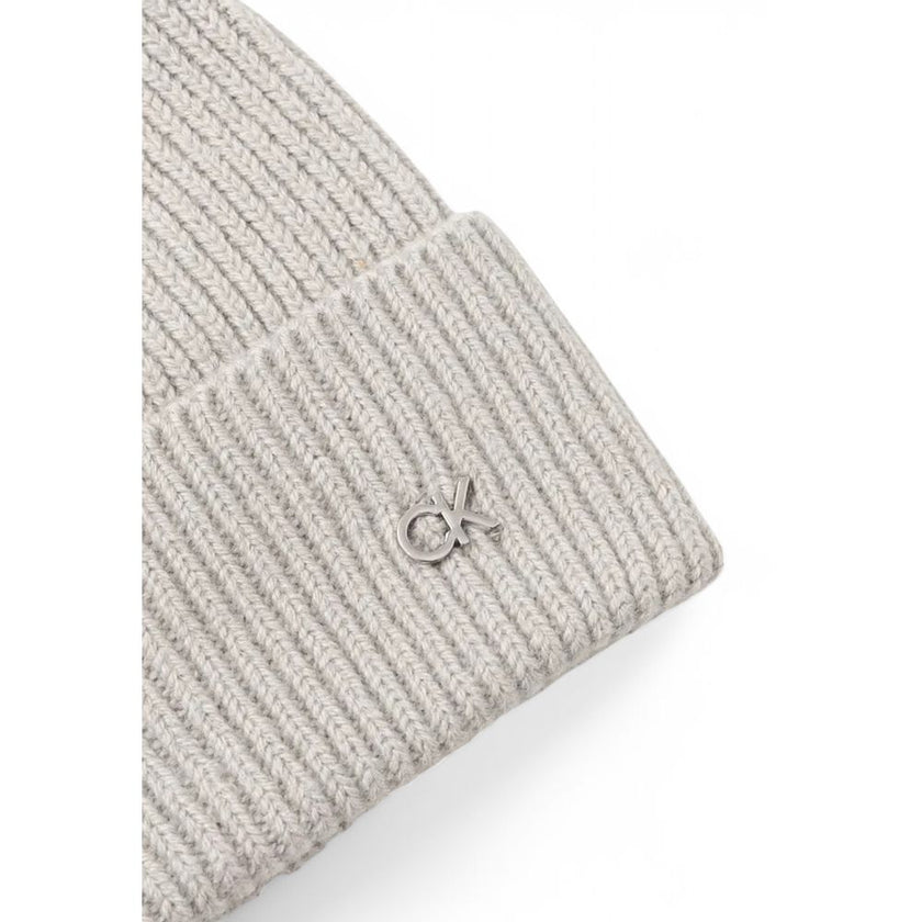 Gray Wool Cap (Baseball Hat)Discover the Calvin Klein CK METAL CHUNKY RIB BEANIE, a stylish and versatile accessory for your winter wardrobe. Made from high-quality materials, 90% wool and 10% cashmere, this beanie offers exceptional softness and warmth,