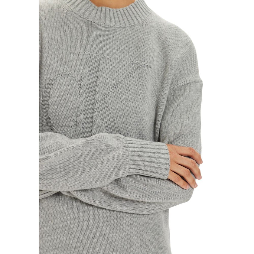 Gray Organic Cotton ShortDiscover the Calvin Klein Jeans CK Intarsia Loose short dress for women, a piece that combines comfort and style. Made from a blend of 55% organic cotton, 35% cotton, and 10% wool, this dress is perfect for cooler days. The loose