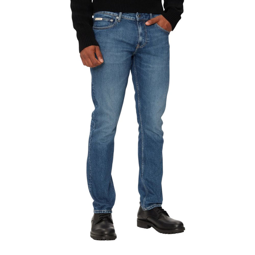 Blue Cotton Skinny JeanThe Calvin Klein Jeans J30J326359 slim fit jeans for men represent a perfect blend of style and sustainability. Made with a composition of 79% cotton, 20% recycled cotton, and 1% elastane, these jeans provide a snug and comfortable