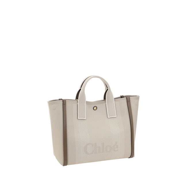 Beige Cotton HandbagChloé’s Carry Handbag is a refined and versatile accessory made of cotton with contrasting leather details that accentuate its elegance. The snap top closure provides practicality, while the double flat handles and leather extension on