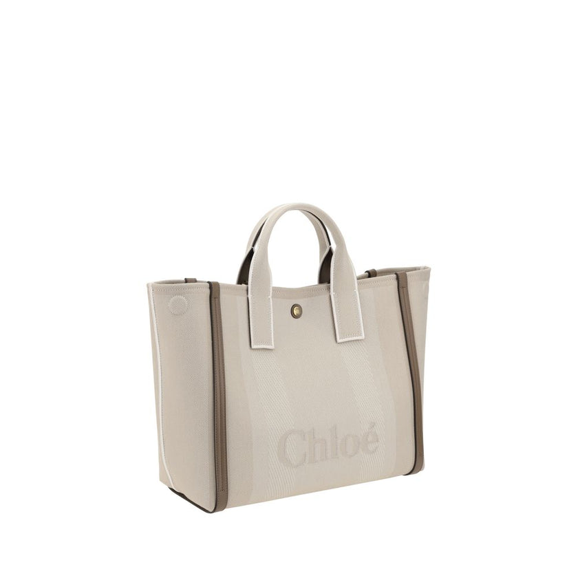 Beige Cotton HandbagChloé’s Carry Handbag is a refined and versatile accessory made of cotton with contrasting leather details that accentuate its elegance. The snap top closure provides practicality, while the double flat handles and leather extension on