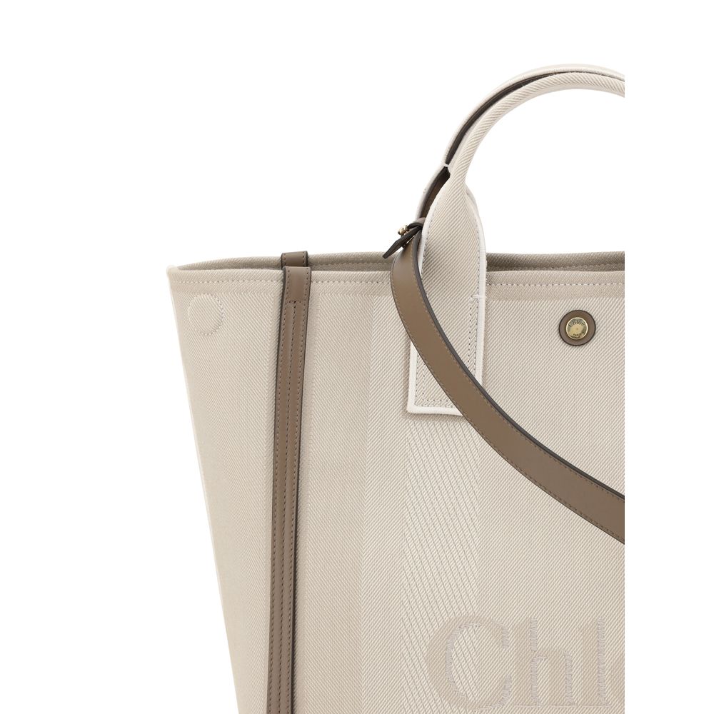 Beige Cotton HandbagChloé’s Carry Handbag is a refined and versatile accessory made of cotton with contrasting leather details that accentuate its elegance. The snap top closure provides practicality, while the double flat handles and leather extension on