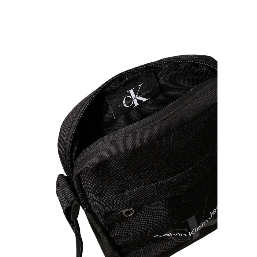 Black Recycled Polyester Messenger BagThe Calvin Klein SPORT ESSENTIALS REPORTER18 M K50K512011 men’s crossbody bag is the perfect accessory for those seeking practicality and style. Made from 100% recycled polyester, this bag is not only sustainable but