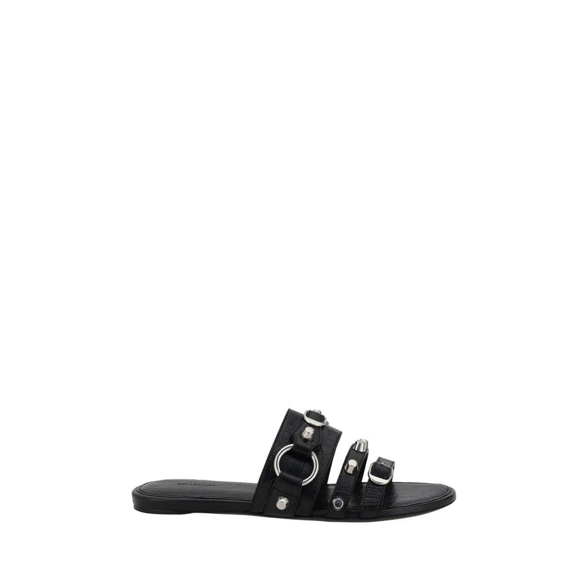 Black Calf Leather Bos Taurus Flat SandalsBalenciaga’s studded Sandals combine a bold and sophisticated design. A slip-on model with a flat sole, they feature three front straps decorated with silver studs and rings, giving them a modern, rock look. These