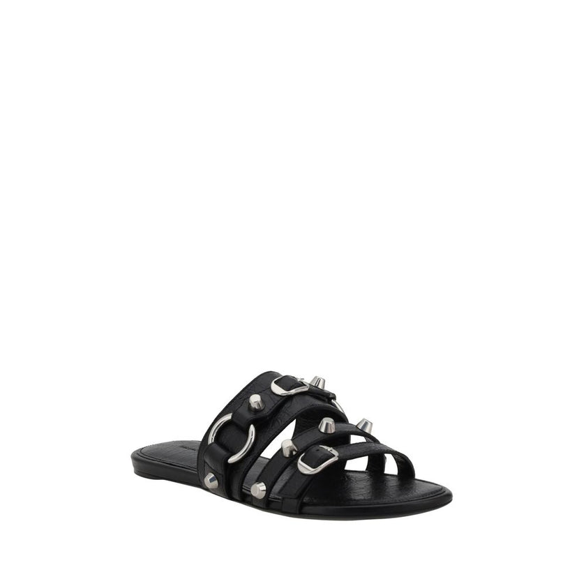 Black Calf Leather Bos Taurus Flat SandalsBalenciaga’s studded Sandals combine a bold and sophisticated design. A slip-on model with a flat sole, they feature three front straps decorated with silver studs and rings, giving them a modern, rock look. These