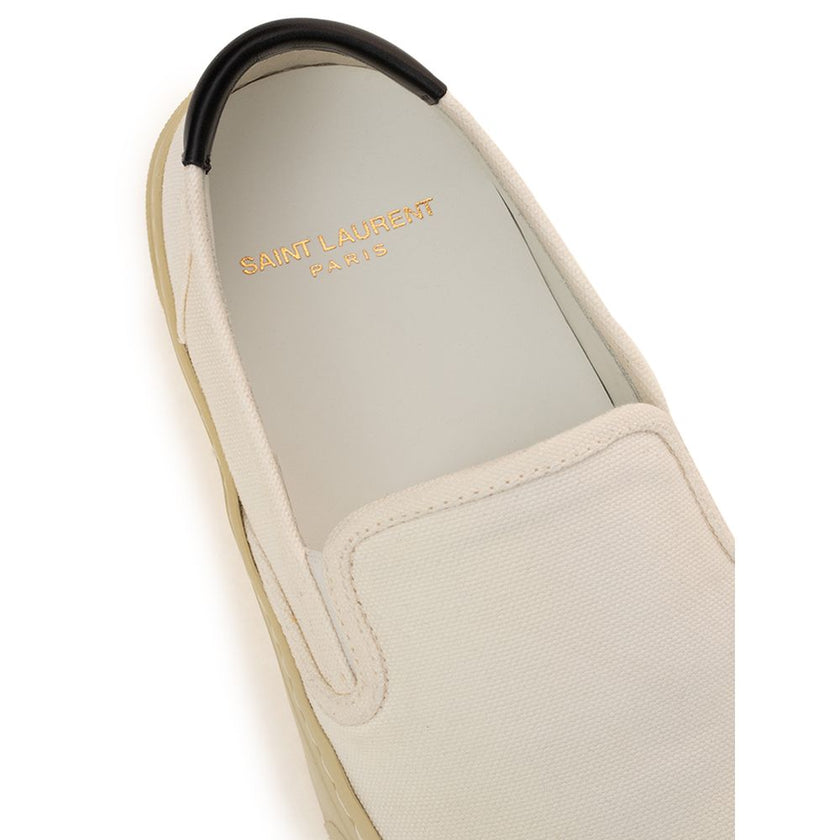White Cotton Low Top SneakersWhite Canvas Slip-On Saint Laurent. Venice slip-on in cotton canvas, tone-on-tone rubber sole, round toe, black leather back tab with logo. Printed logo on the back. Sole height: 3 cm. Composition: 100% Cotton, leather interio