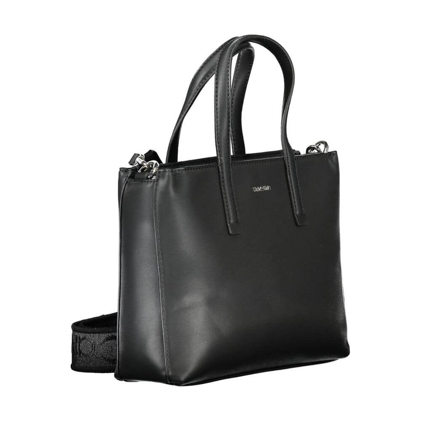 Black Polyester Women HandbagUnleash the epitome of urban-chic with the Calvin Klein masterpiece that seamlessly blends sustainability with style. Imagine the touch of sophistication with a bag that boasts dual handles for sheer elegance, a versatile adju