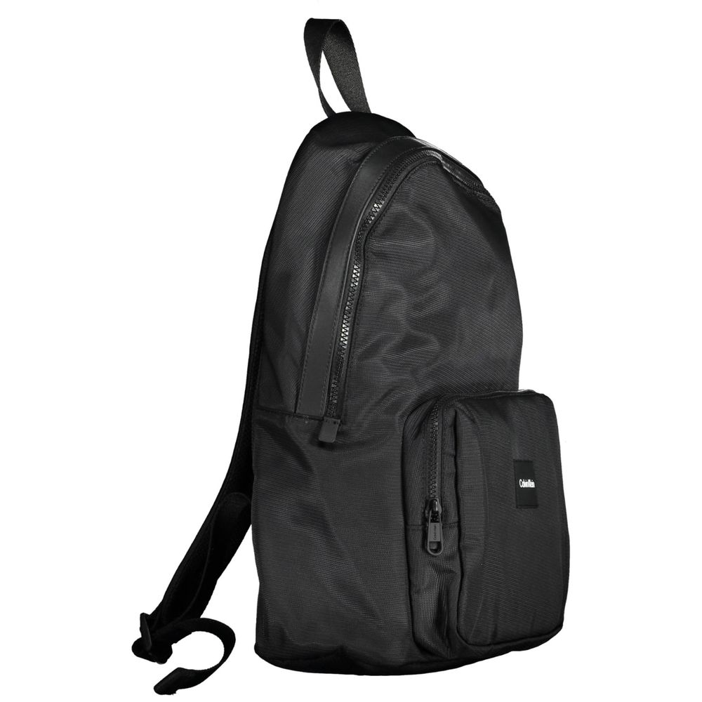 Black Polyester Men BackpackElevate your style with the sleek and sophisticated Calvin Klein backpack. Crafted for the urban trendsetter, this backpack stands out with its bold logo and contemporary design. With adjustable straps and a range of pockets, i