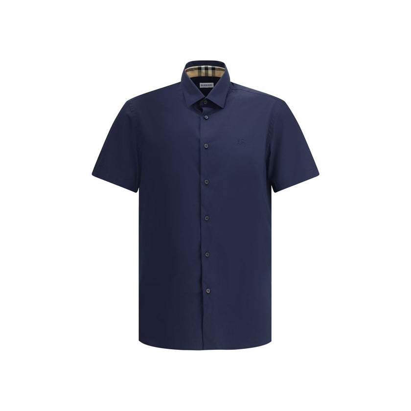 Blue Cotton Shortsleeve ShirtBurberry’s Short Sleeve Shirt combines essential elegance with iconic details. Featuring a classic collar and front button closure, it is distinguished by the iconic Equestrian Knight logo sewn on the front, which adds a touch