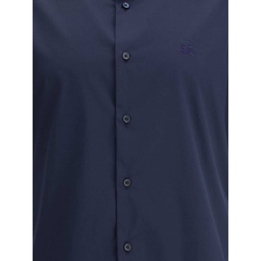 Blue Cotton Shortsleeve ShirtBurberry’s Short Sleeve Shirt combines essential elegance with iconic details. Featuring a classic collar and front button closure, it is distinguished by the iconic Equestrian Knight logo sewn on the front, which adds a touch