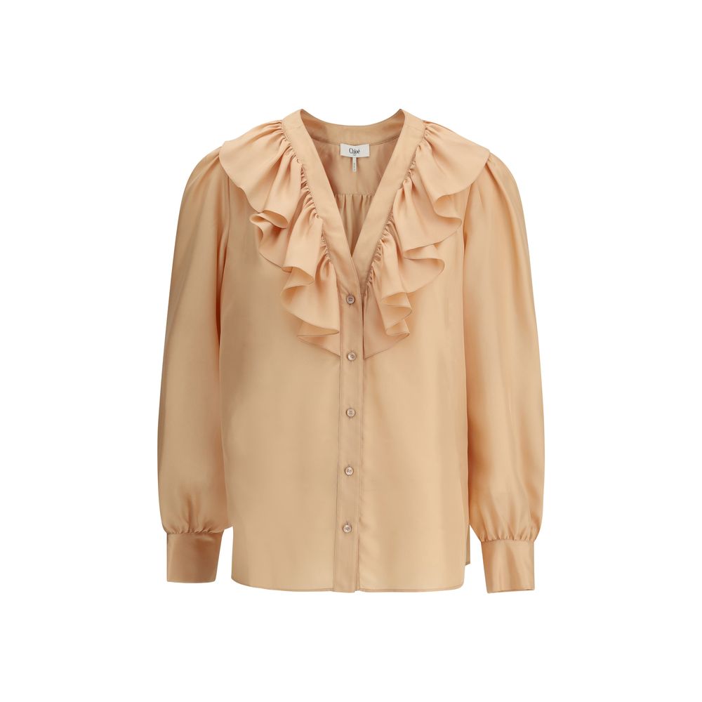 Ruffle ShirtChloé’s Habotai Silk Ruffle Shirt by Chloé is a romantic and sophisticated piece, perfect for adding an ethereal touch to your wardrobe. Featuring a V-neckline and a delicate row of ruffles on the front, it expresses femininity with lightness
