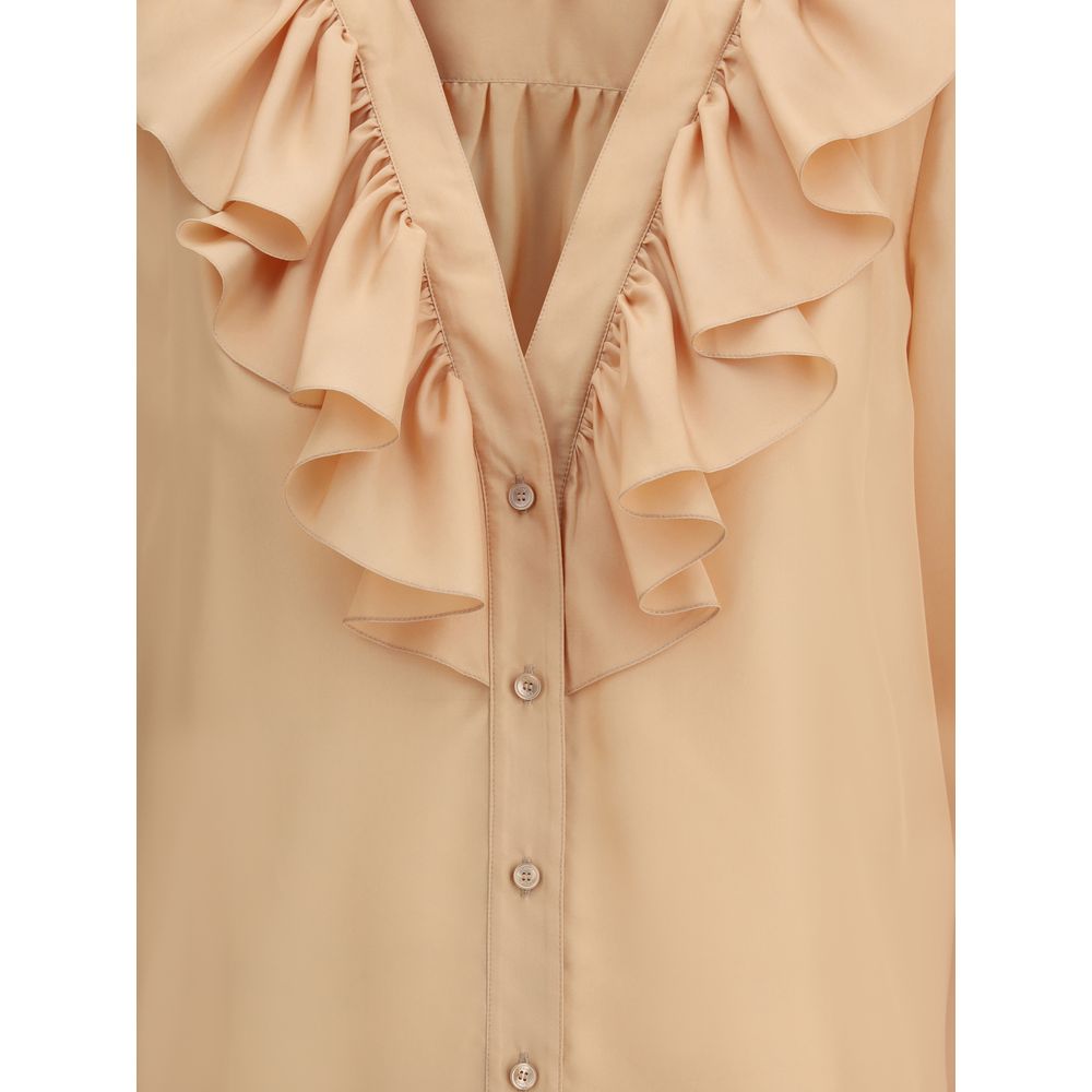 Ruffle ShirtChloé’s Habotai Silk Ruffle Shirt by Chloé is a romantic and sophisticated piece, perfect for adding an ethereal touch to your wardrobe. Featuring a V-neckline and a delicate row of ruffles on the front, it expresses femininity with lightness