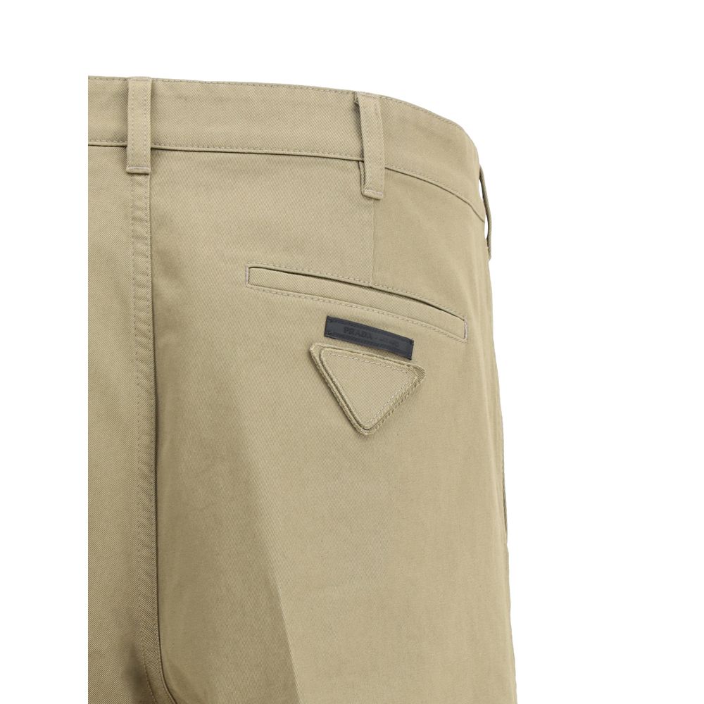 Beige Cotton Chino PantsPrada’s chino Pants offer essential elegance with contemporary style. Featuring a front zipper and button closure, they feature two side welt pockets and back pockets, one of which is embellished with the brand’s iconic logo. Waist