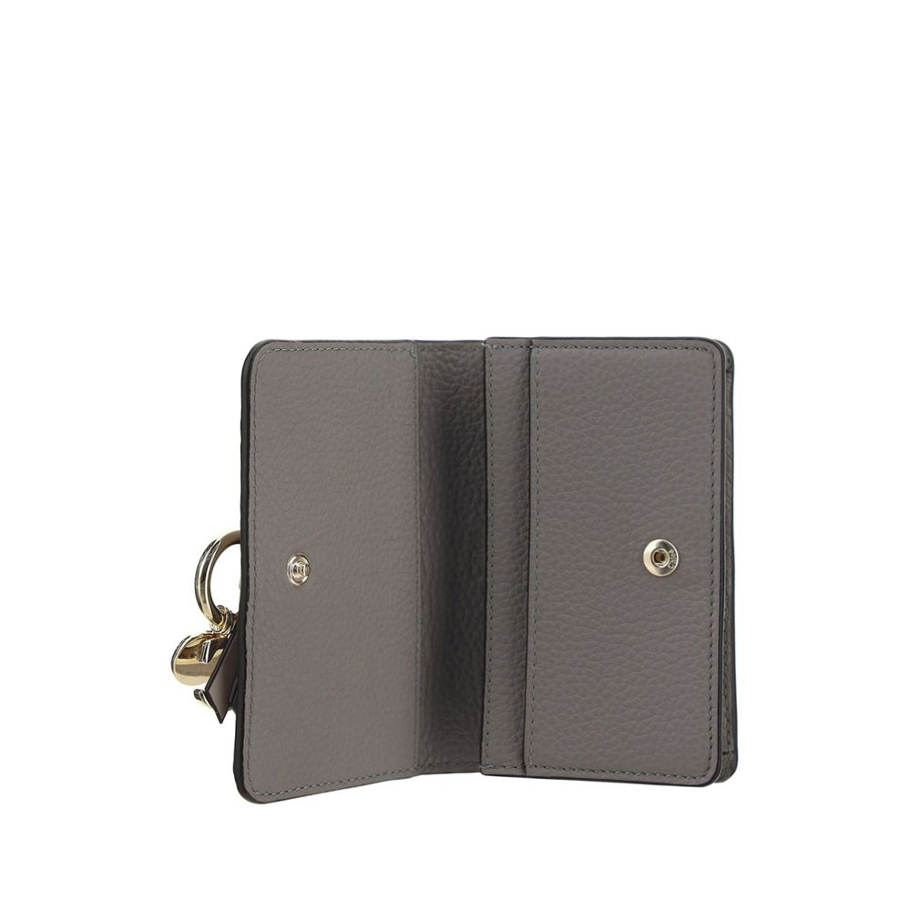 Gray Calf Leather Bos Taurus WalletAlphabet by Chloé Wallet in grained leather, elegant and functional. Featuring a charm detail that adds a touch of personality, it has a snap-button closure for security and convenience. Inside, it features a main compar